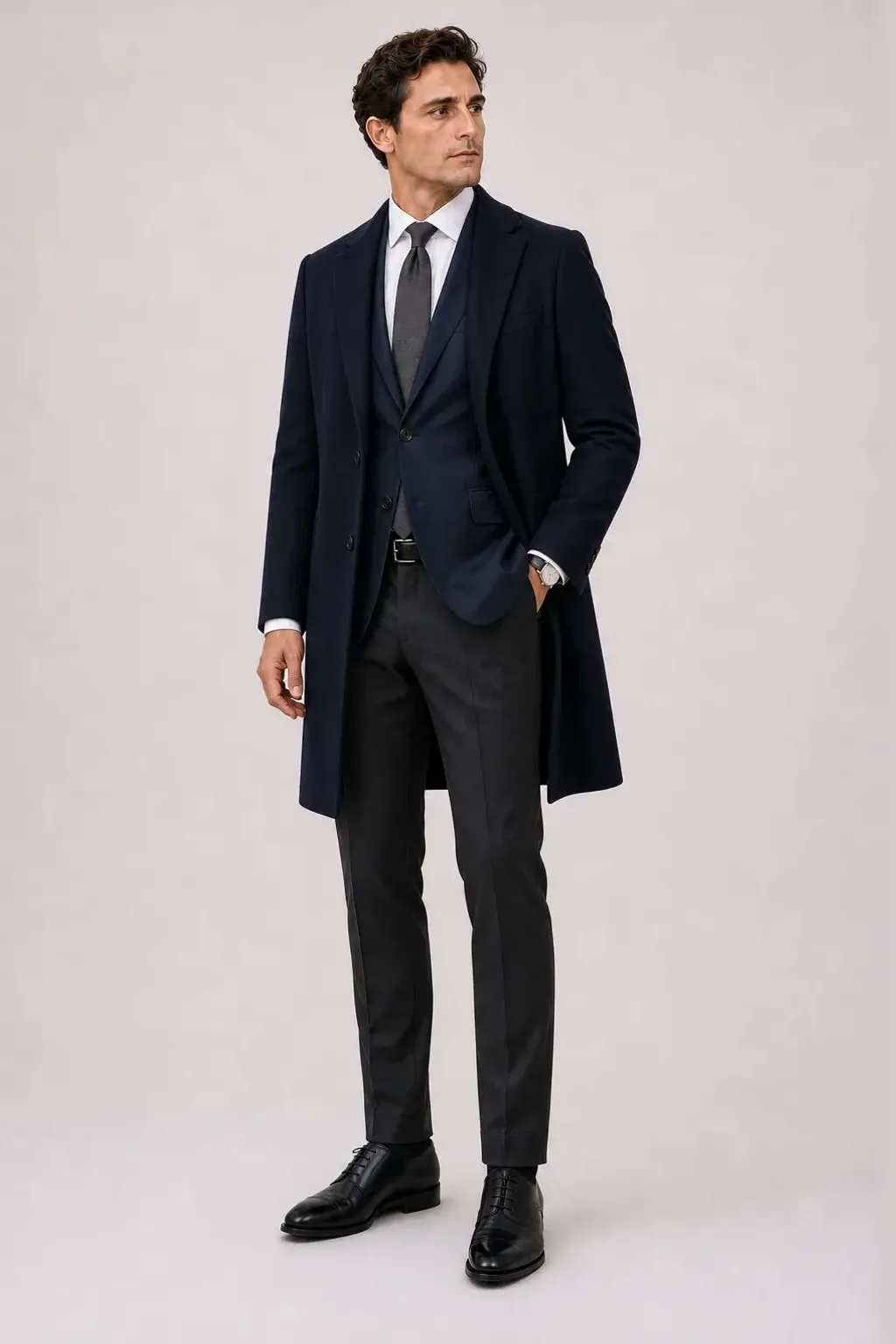Langer Mantel Navy über Sakko Navy und Business-Hemd Weiss, dazu Anzughose Wolle Dunkelgrau und Derby