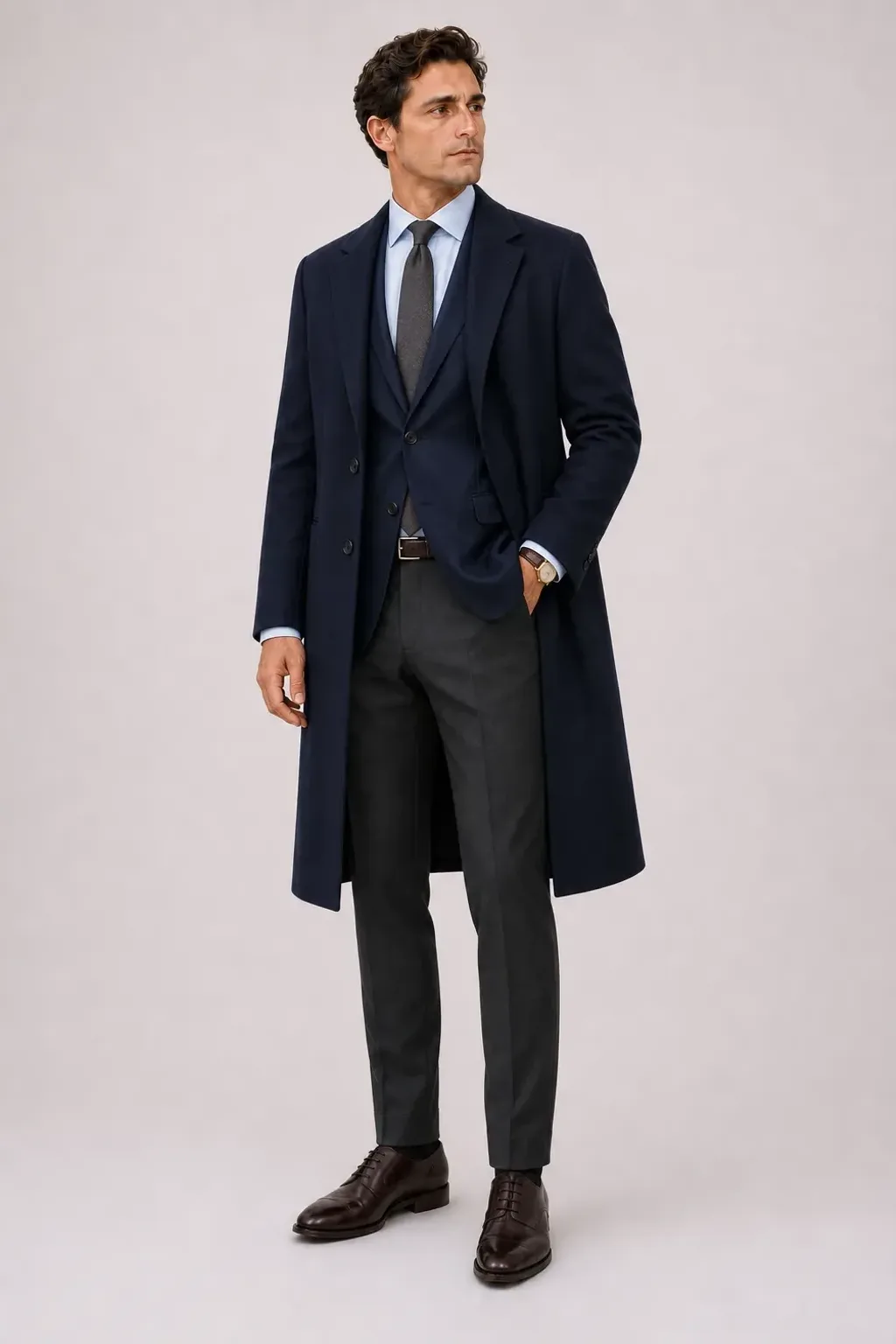 Langer Mantel Navy über Sakko Navy und Business-Hemd Hellblau, dazu Anzughose Wolle Dunkelgrau und Derby