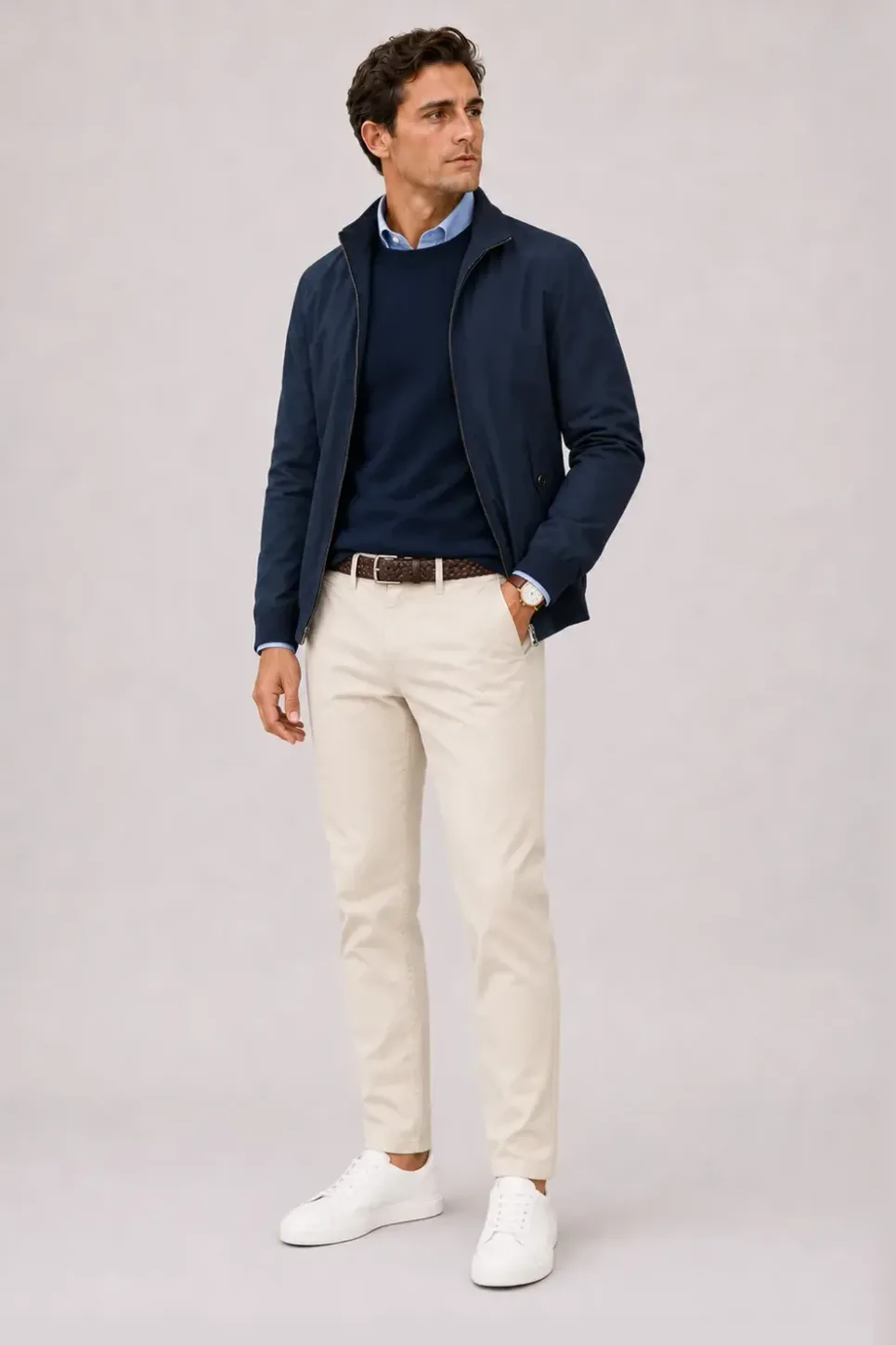 Harrington Blouson Navy über Crewneck-Pullover Feinstrick Navy und Button-Down-Hemd Hellblau, dazu Chino Creme und Sneaker